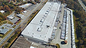 Large commercial distribution storehouse with many semitrucks unloading and uploading retail products for international