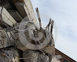 Large concrete chunks with twisted metal and industrial building