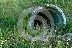 A large concrete pipe for diverting the river under the highway. Leaky dirty water from large concrete pipes. Dirty sewage from photo