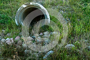 A large concrete pipe for diverting the river under the highway. Leaky dirty water from large concrete pipes. Dirty sewage from photo