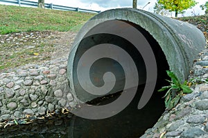 A large concrete pipe for diverting the river under the highway. Leaky dirty water from large concrete pipes. Dirty sewage from