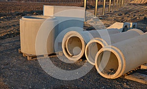 Large concrete rings for the installation of sewers lined up on the construction site for storage in the excavation. concrete prod