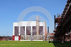 A large concrete technological industrial installation at a chemical petrochemical refinery with capacitive pipes by pumps