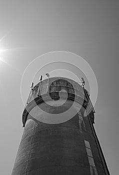 Large, concrete water tower with telecom and wireless 4G antennas.