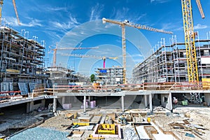 Large construction site with foundations, scaffolding and cranes