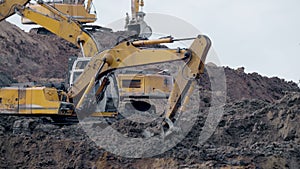 Large construction yellow excavators on construction site in quarry