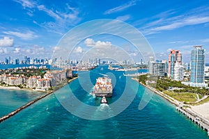 Large Container Ship Entering Harbor and Miami City on Sunny Day, USA. Aerial View