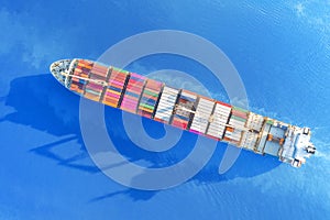 Large container ship sailing blue sea. Top aerial view