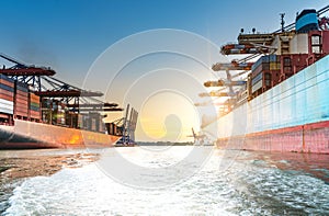 Large container ships in harbor at sunset