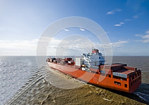 Large container vessel ship heading out to the sea.