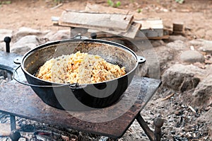 Large cooking pot with finished pilaff, a rice, carrot and mutton meat dish. Rice pilaf series photo