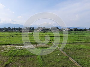 LARGE COUNTRY FIELD FARAWAY LOCAL ITY WITH HILLY BACKGROUND