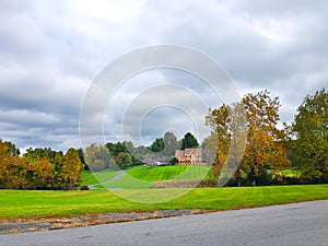 Large country house. Autumn landscape with a large trimmed lawn