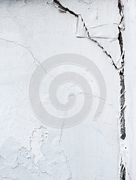 Large crack on the white concrete wall.
