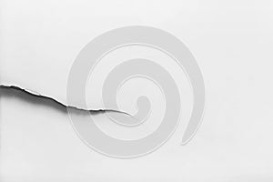 Large crack on a white damaged wall, broken light background, copy space, close-up