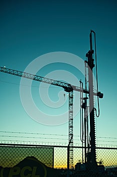 Large Crane and Auger on construction site  silhouette in the evening ligjt