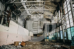 Large creepy abandoned industrial warehouse or factory building inside with broken ruined wall from glass blocks