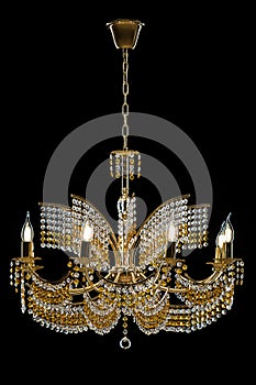 Large crystal chandelier with candles isolated on black background.