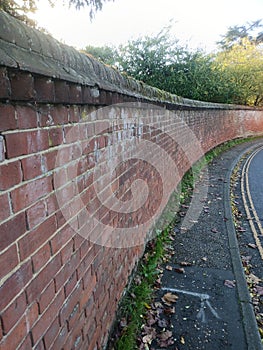 A large curved red brick wall