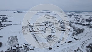 A large dairy farm for breeding cows is covered with snow. Top view.
