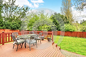 Large deck with dining space overlooking spacious back yard.