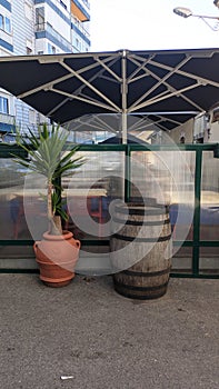 Large decorative pots and an old wooden barrel stand near the wall