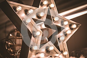 Large decorative retro star with lots of burning lights on grunge concrete background. Beautiful decor, modern design element