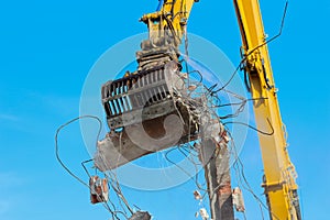 Large demolition crane claw dismantling a building