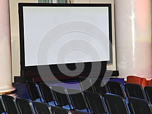 A large demonstration plasma screen and rows of seats for spectators.