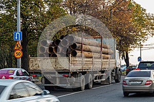 Large diameter metal pipes on a truck, rear view. metal structures plant in Russia.