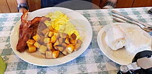 The large diner breakfast of scrambled eggs, bacon, sausage, Hashbrowns, and biscuits and gravy