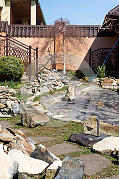 Large dirty stones in the background of the pool. Construction and cleaning of an ornamental pond in the garden. landscape design