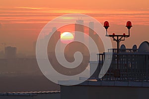 A large disk of sun at sunset between city