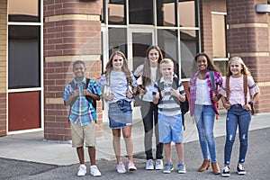 Large, diverse group of kids leaving school at the end of the day. School friends walking together and talking together on their w