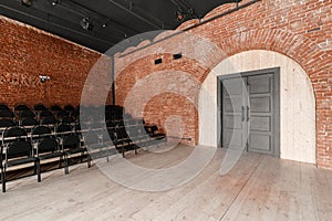 Large door. Loft style. Hall with black chairs for webinars and conferences. A huge room with large Windows, surrounded