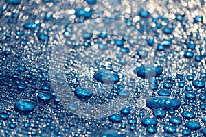 Large drops and splashes of water after rain lie on a blue tarpaulin