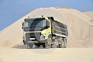 A large dump truck is parked in a quarry