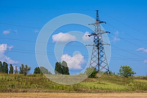 A large electric pole on a hill. Electric pylons. Electricity business. Thick wires. High voltage. Networks for powering