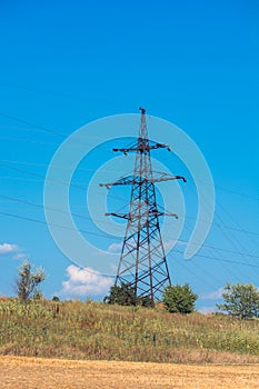 A large electric pole on a hill. Electric pylons. Electricity business. Thick wires. High voltage. Networks for powering