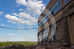 Large empty abandoned warehouse building or factory workshop, abstract blue cloudy sky as a background, copyspace