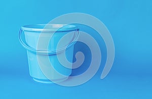 A large empty blue bucket on a blue background