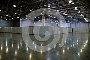 Large empty exhibition hall interior in an industrial building with fencing and high vertical columns with and high ceiling and ar