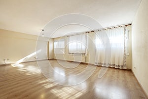 Large empty living room with curtains on the windows