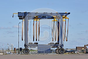 Large empty mobile boat travel lift in a harbour under a blue sky