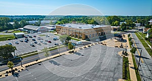 Large empty parking lot and partially full parking lot aerial outside ACD Automobile Museum