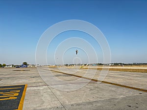 A large empty parking lot with a yellow line on the ground at an Indian airport.