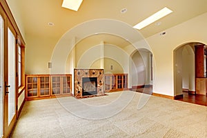 Large empty room with fireplace and shelves. New luxury home interior.