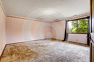 Large empty room with soft carpet floor, one window