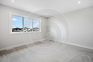 Large, empty room with a window and a white wall