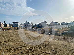 A large empty wasteland with dust and sand, a prepared construction site for the development of cottage buildings in a warm